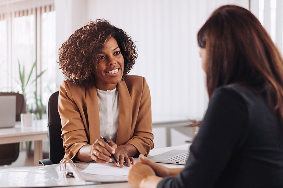 Insurance Agent Insurance - Engaged Insurance Agent Talking to a Potential Client Across the Table